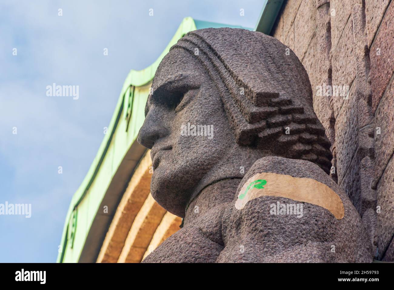 Laterne trägt Steinstatuen von Erik Wiksrtöm mit kovidierten Impfhilfen auf ihren Armen am Bahnhof in Helsinki Finnland Stockfoto