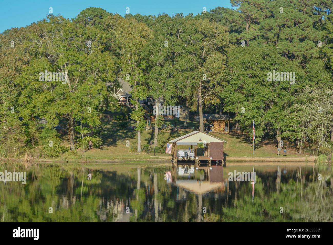 Spiegelbild am Lake Cherokee mit Bootshäusern und Bäumen. In East Henderson, Rusk County, Texas Stockfoto