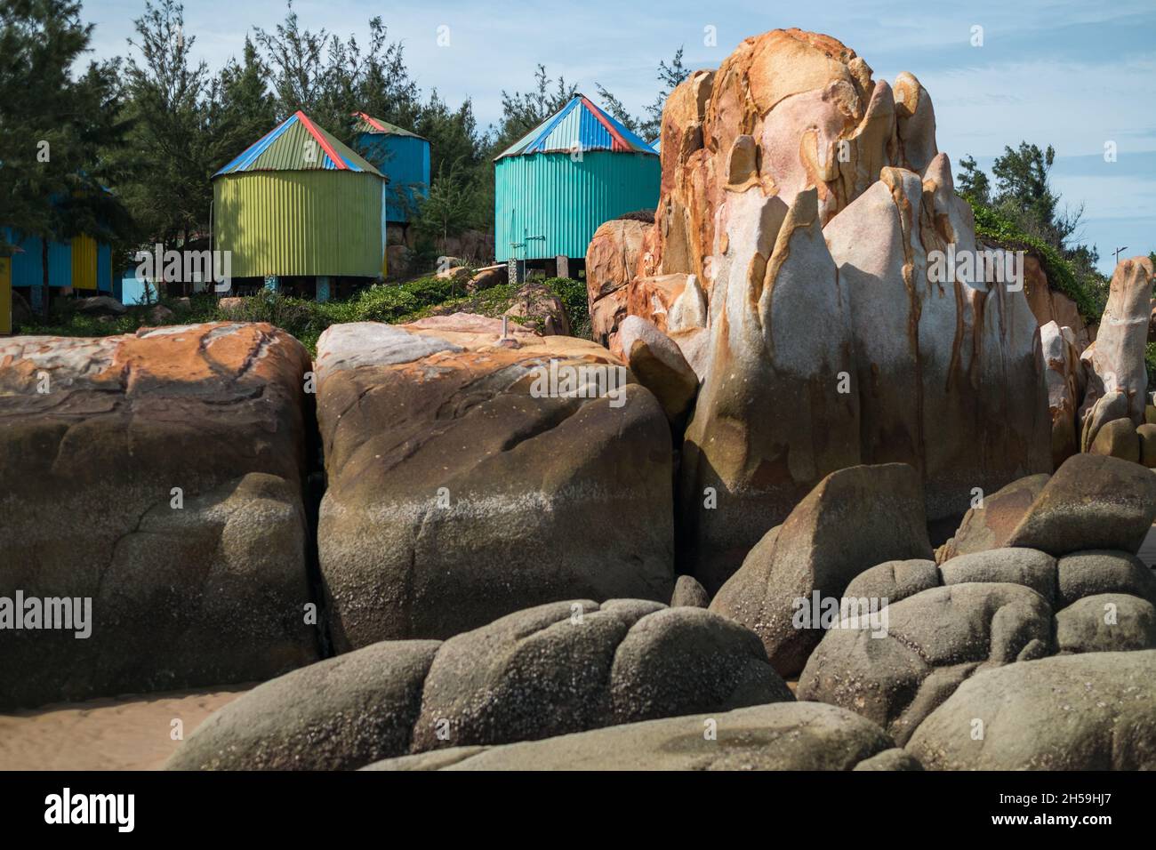 Strand mit großen Steinen und bunten Ständen. Bunte Häuser am Meer. Hochwertige Fotos Stockfoto