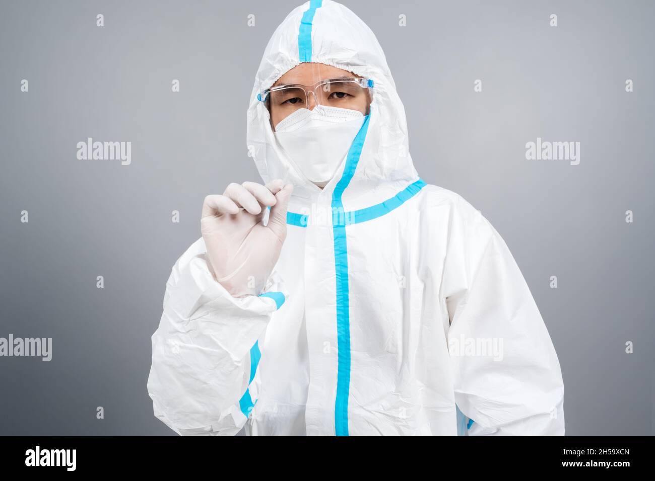 Männlicher Arzt in Schutzanzug, PPE mit Coronavirus(COVID-19) Nasal-Abstrichlabortest Stockfoto