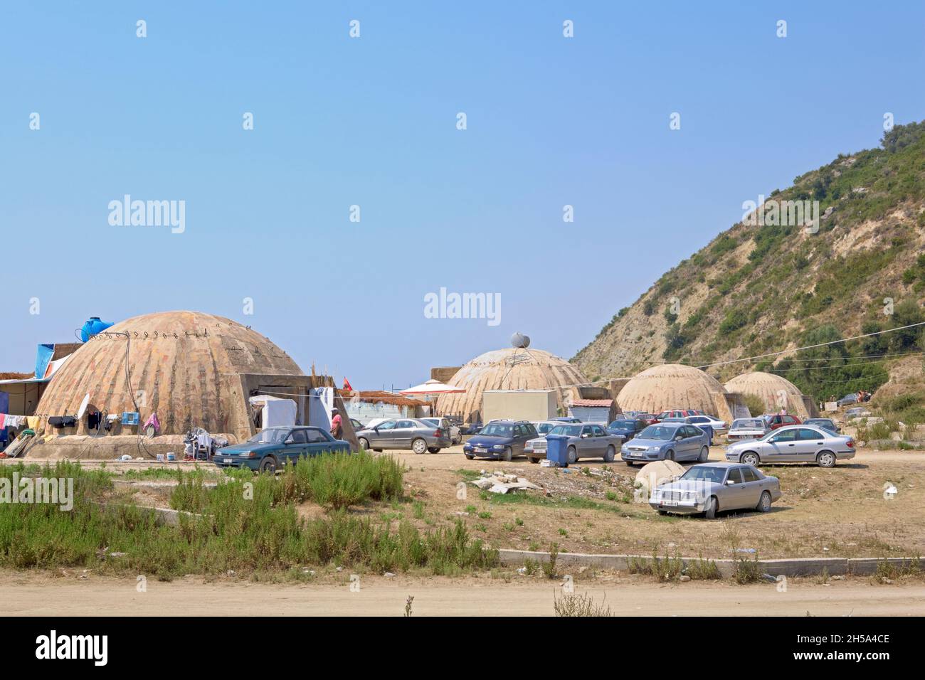 Große Artilleriebunker des Kalten Krieges, die jetzt als Cafés an einem Strand, Bunec, Albanien, genutzt werden Stockfoto