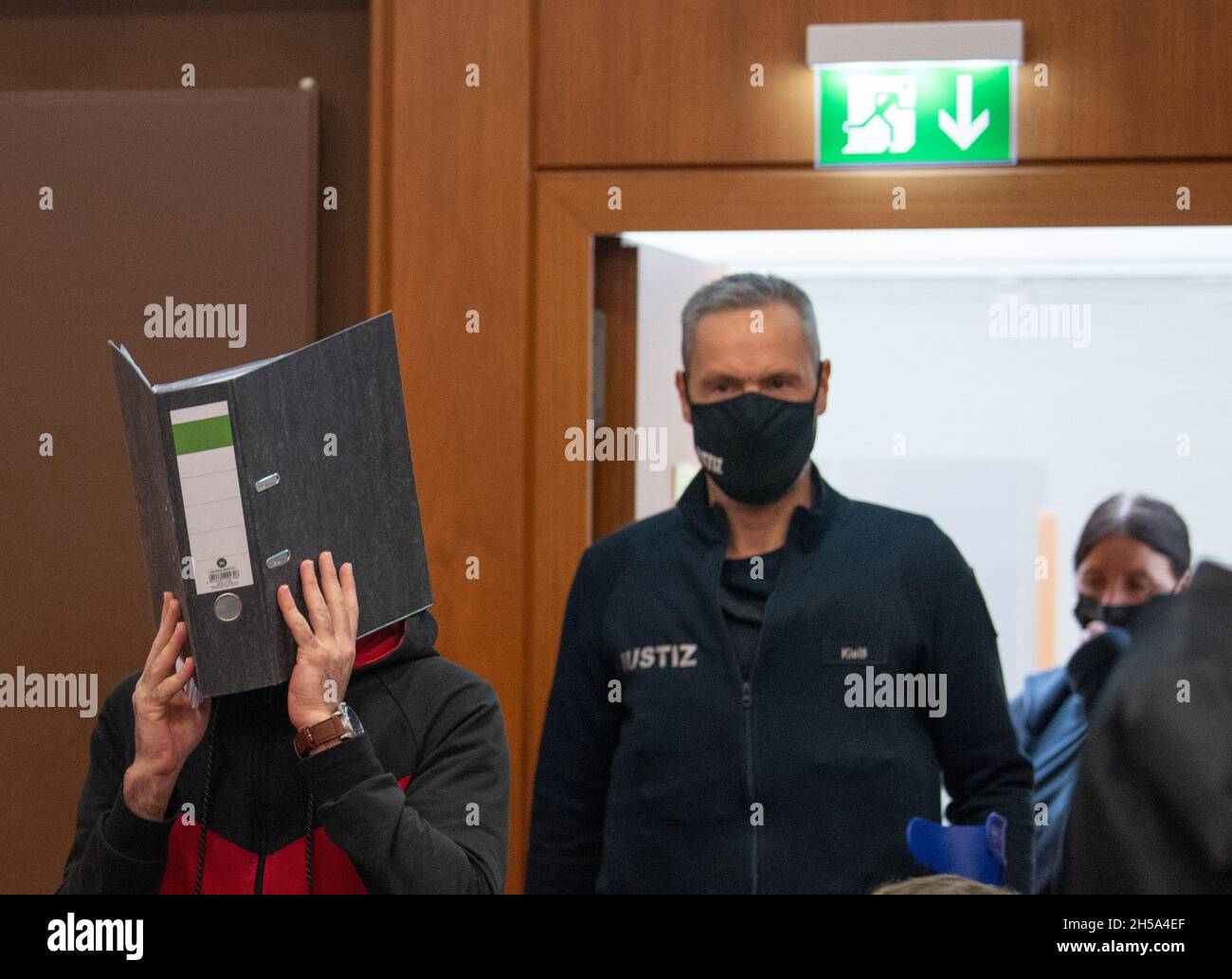 08. November 2021, Hessen, Frankfurt/Main: Die Angeklagte Irakin Taha Al-J. wird in den Hochsicherheitsraum geführt. Die Staatsanwaltschaft wirft ihm Völkermord, Verbrechen gegen die Menschlichkeit, Kriegsverbrechen, Menschenhandel und Mord vor. Als mutmaßliches Mitglied der Terrormiliz IS soll er eine yezidische Frau und ihre Tochter als Sklaven festgehalten und missbraucht haben. Dabei soll er den fünfjährigen in Falludscha, Irak, gefesselt haben, wo das Kind laut Anklageschrift vor Schmerzen verdurstet starb. Foto: Boris Roessler/dpa Stockfoto