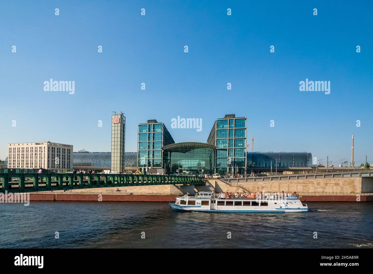 Schöne Aussicht auf ein Schiff auf der Spree an der Fußgängerbrücke Gustav-Heinemann-Brücke, vorbei am Hauptbahnhof Berlin... Stockfoto