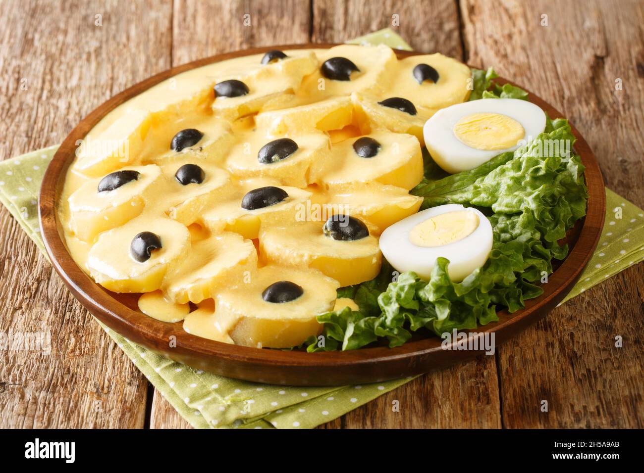 Peruanische Küche die gekochten Kartoffeln Papa a la huancaina oder Kartoffeln im Huancayo-Stil werden mit einer cremigen Käsesoße in der Nähe auf dem Teller auf der Registerkarte gekrönt Stockfoto