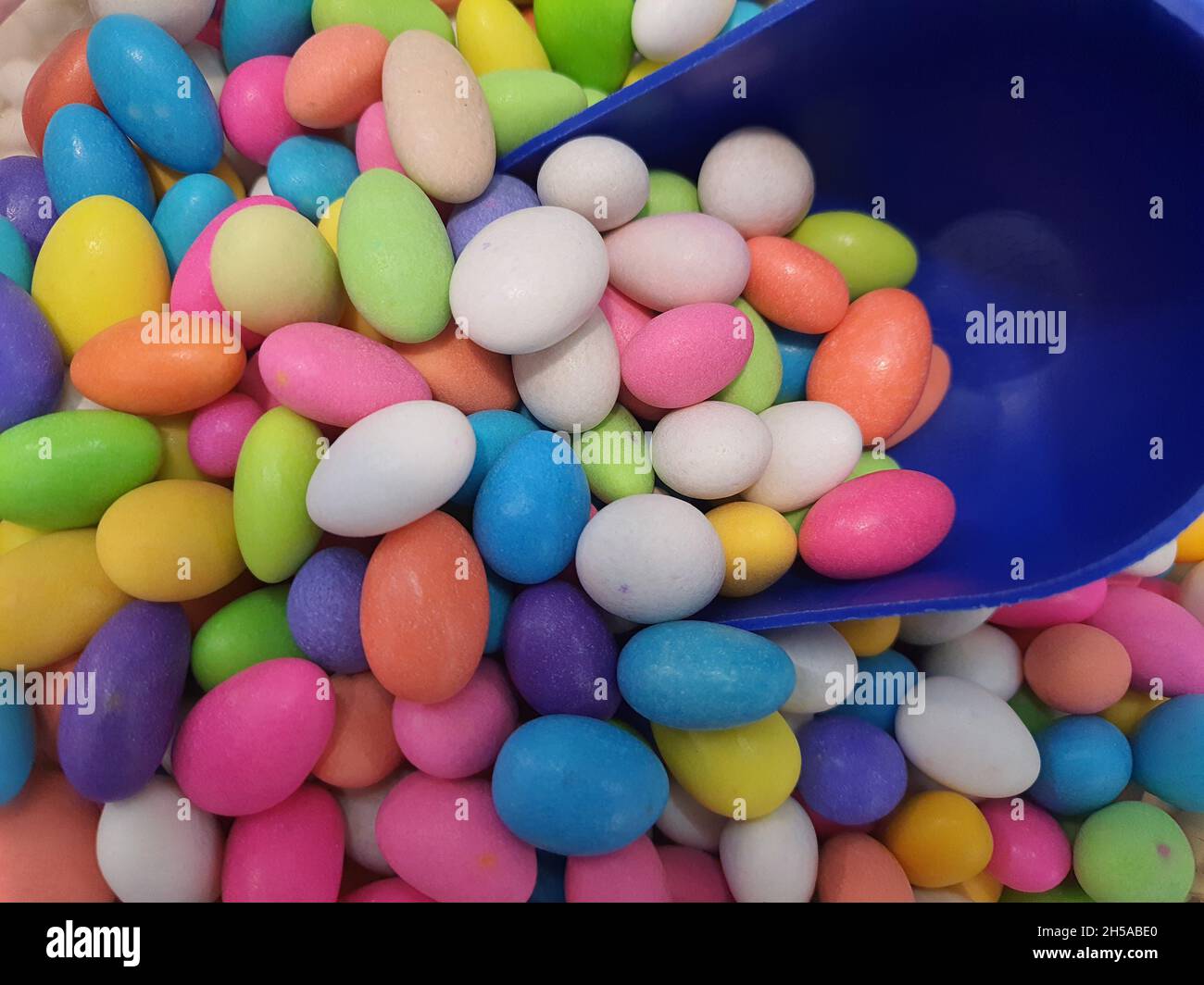 Hintergrund der farbigen Schokolade mit farbigem Zucker bedeckt, im Fachgeschäft, Süßigkeiten oder Desserts. Hintergründe und Texturen. Stockfoto