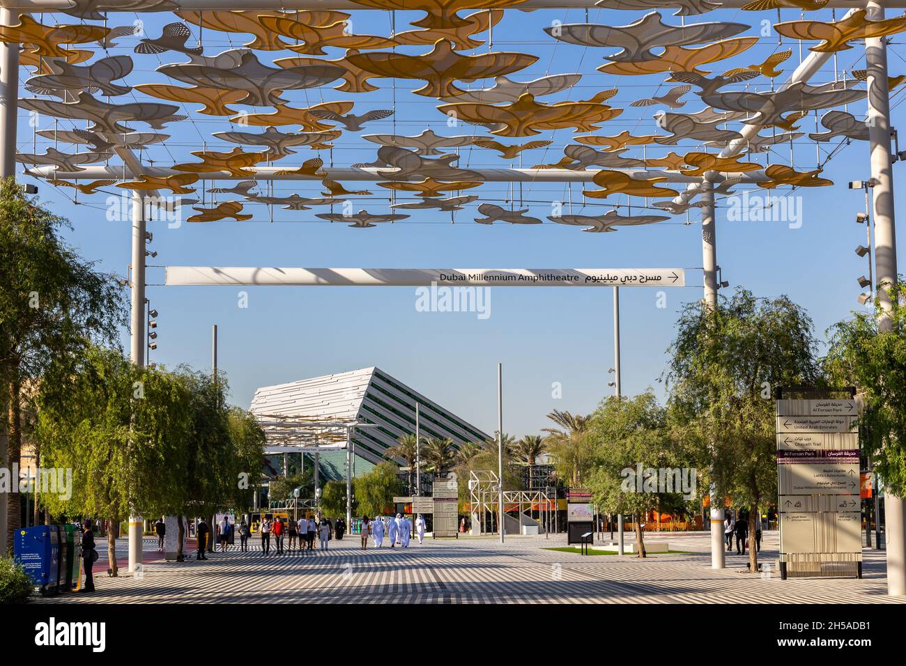 Dubai, VAE, 27.10.2021. Expo 2020 Dubai, Fußweg mit vogelförmigem Sonnenschutzdach und People Walking, Saudi Arabia Pavilion im Hintergrund. Stockfoto