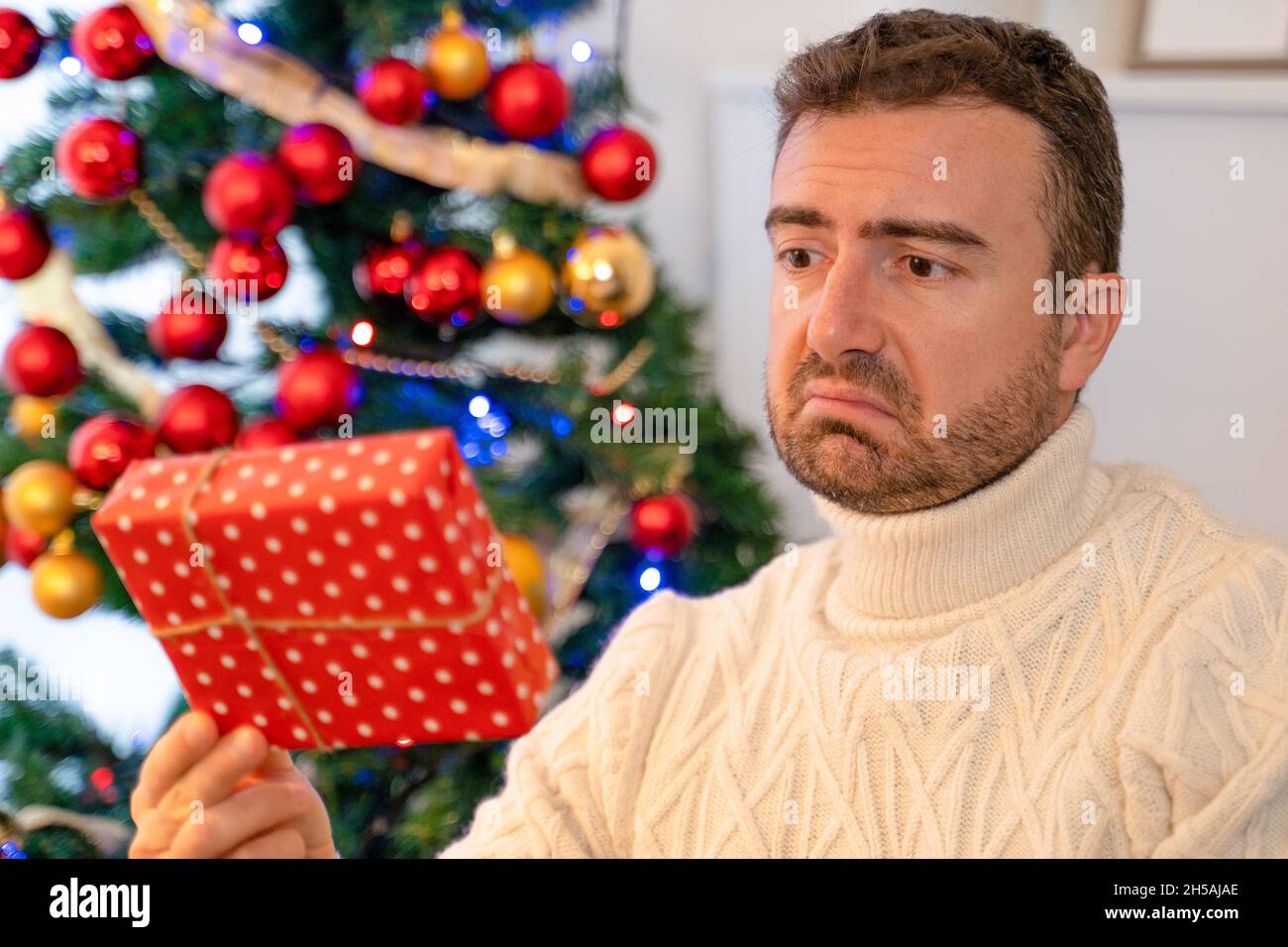 Ein Mann, der klein und enttäuschend weihnachten Geschenk Stockfoto