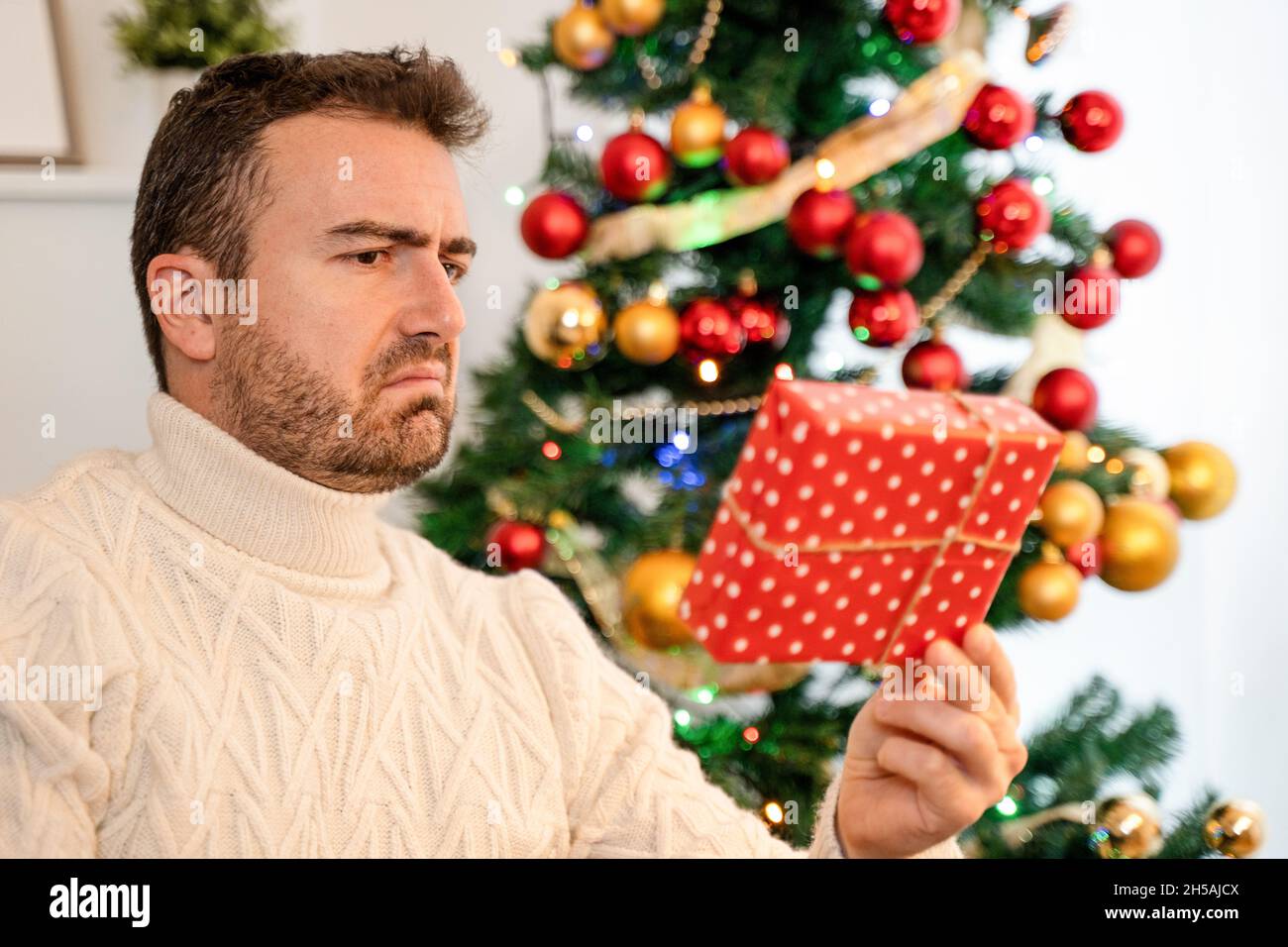 Mann, der sich für ein schlechtes Weihnachtsgeschenk enttäuscht fühlte Stockfoto