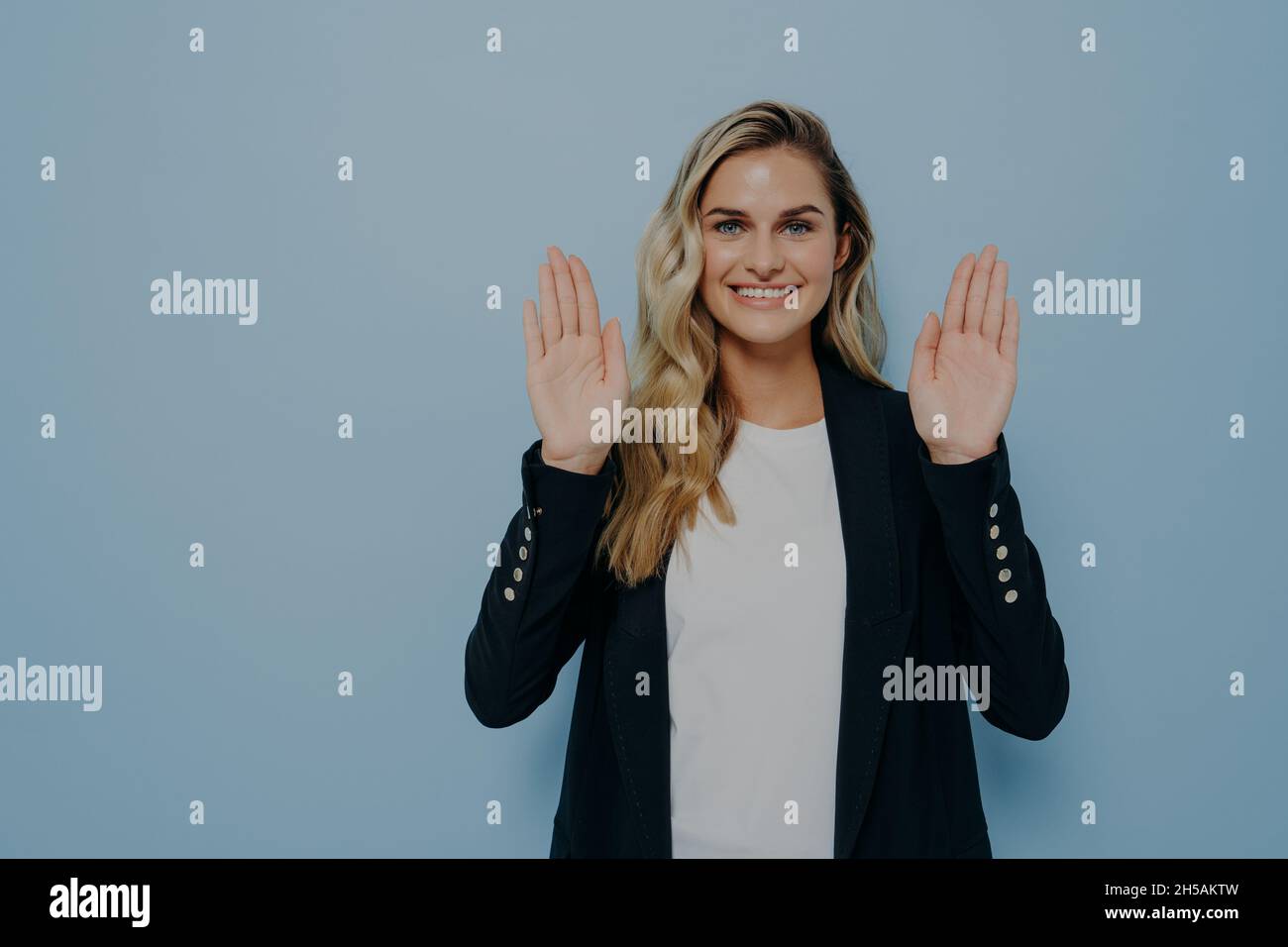 Frau weigert sich höflich lächelnd freundlich mit positivem Blick als winkende Hände in Stop-Geste Stockfoto