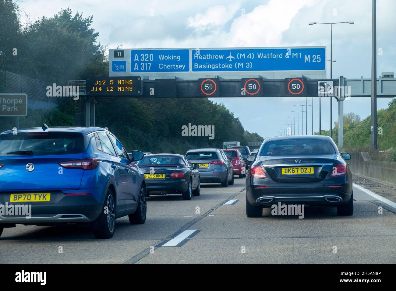 Verkehrsgeschwindigkeitsbeschränkungen und Fahrzeuge auf der Autobahn M25, London, England. Stockfoto