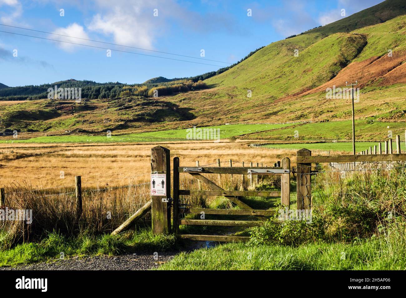 Tor auf Fußweg mit COVID-Zeichen für soziale Distanz im Snowdonia-Nationalpark im Herbst. Rhyd DDU, Gwynedd, North Wales, Großbritannien Stockfoto
