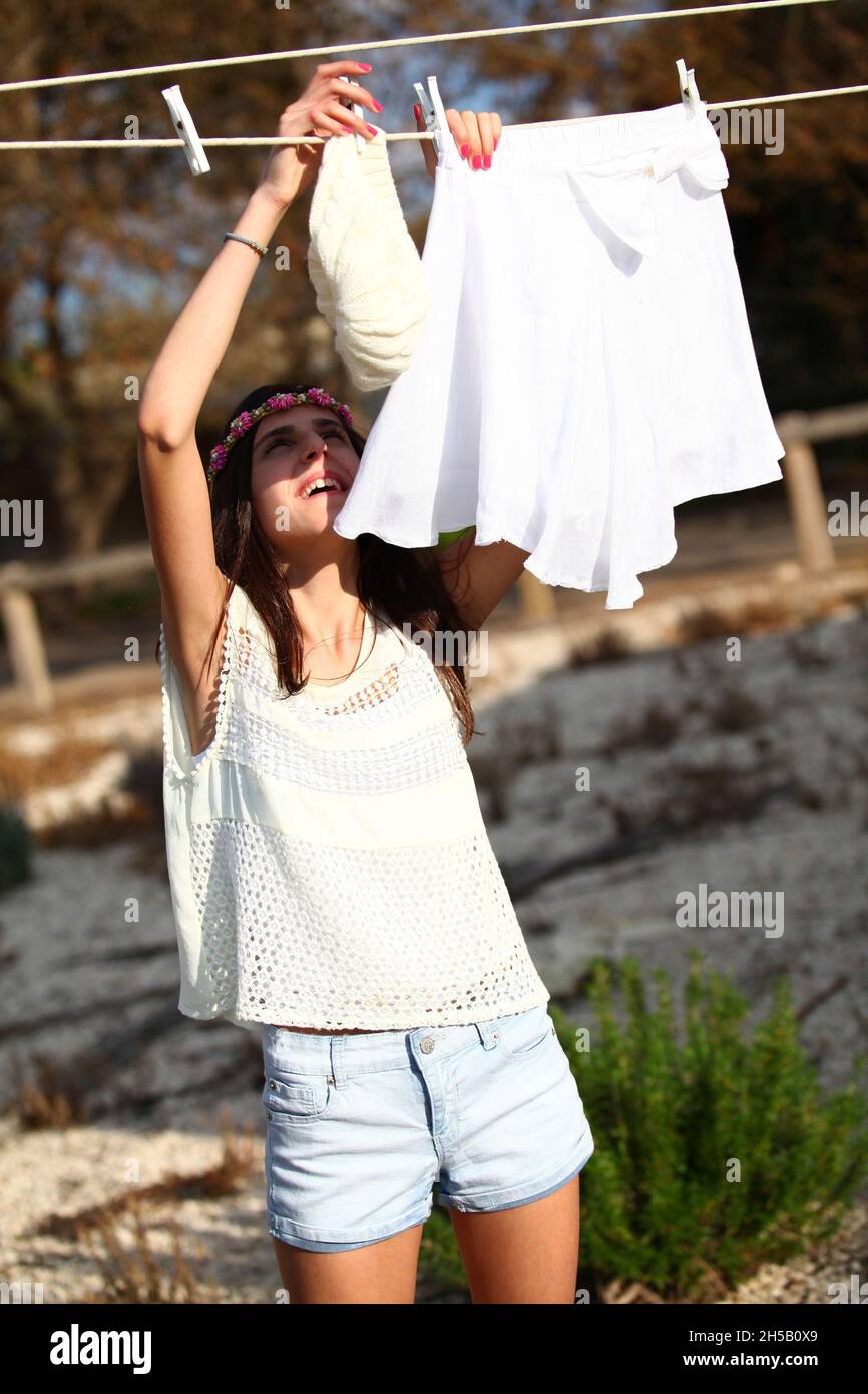 Junger Teenager, der Hausarbeiten macht und Waschen an einer Wäscheleine hängt Stockfoto