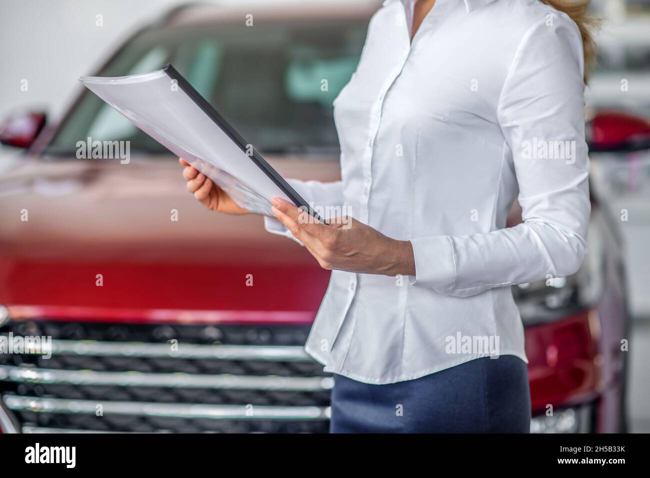 Hände der Womans in weißer Bluse, die Dokument halten Stockfoto