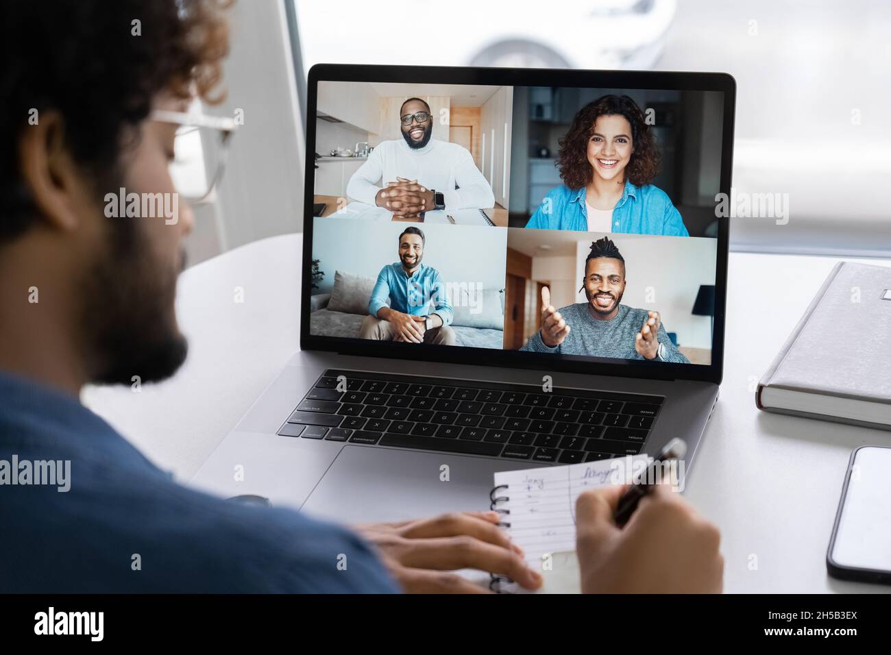 Webcam-Gruppenkonferenz mit Kollegen auf einem modernen Laptop vom Heimbüro aus Stockfoto