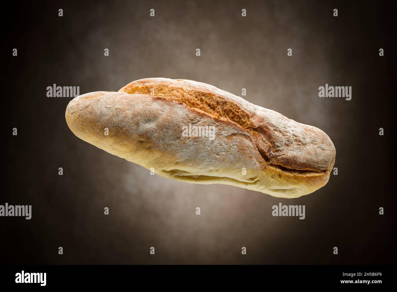 Frisches, knusprig gebackenes Brot auf braunem Hintergrund. Stockfoto