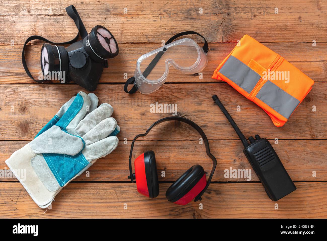 Persönliche Schutzausrüstung für die Arbeit. Arbeitsschutz für Industrie und Baustelle. Schutzausrüstung auf Holzhintergrund, Stockfoto