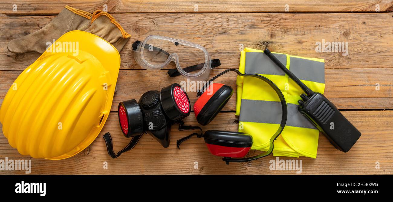 Persönliche Schutzausrüstung für die Arbeit. Arbeitsschutz für Industrie und Baustelle. Schutzausrüstung auf Holzhintergrund, Stockfoto