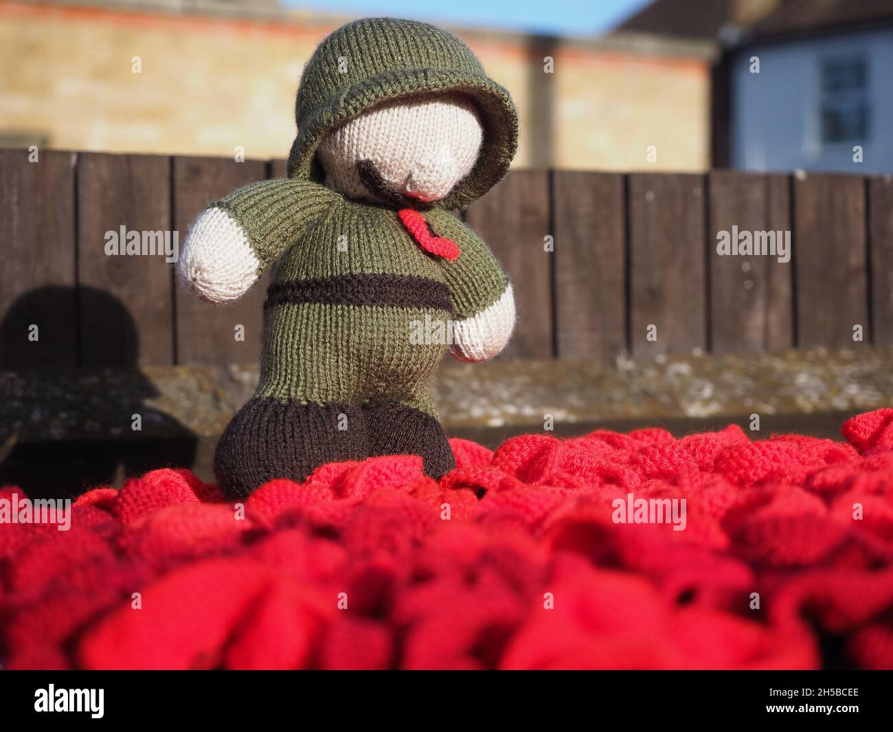 Upchurch, Kent, Großbritannien. November 2021. Ein gestrickter/gehäkelter Briefkastenauftoper mit Erinnerungsmotiven / „Hut“ - mit einem Solider, der auf Mohnblumen in Upchurch, Kent, steht. Kredit: James Bell/Alamy Live Nachrichten Stockfoto