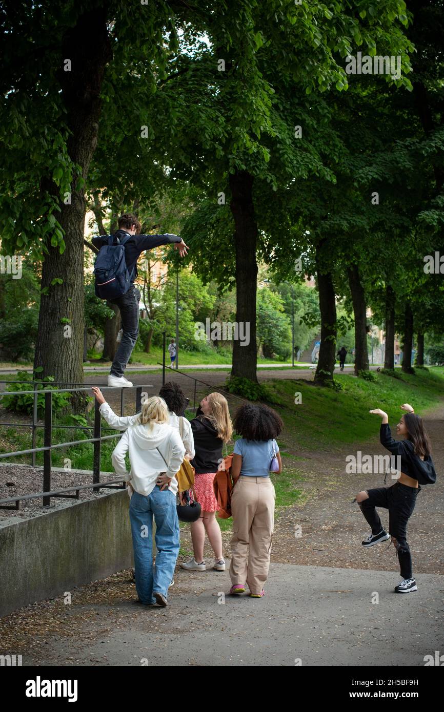 Teenager-Freundinnen und -Freunde, die im Park spielen Stockfoto