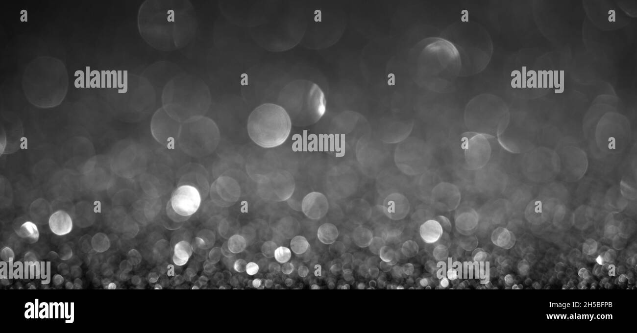 Schwarze Weihnachtslichter Hintergrund, Banner-Design. Glänzende, leuchtende Oberfläche mit Bokeh, abstrakter, unfokussierten Glitzer mit einem Funkeln Stockfoto