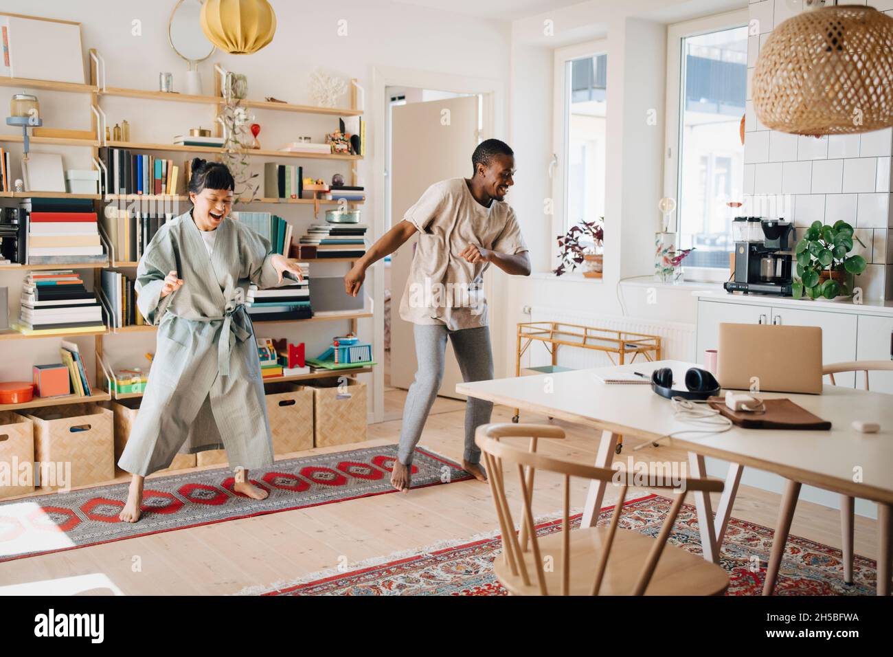 Fröhliche Freundin und Freund tanzen zu Hause zusammen Stockfoto