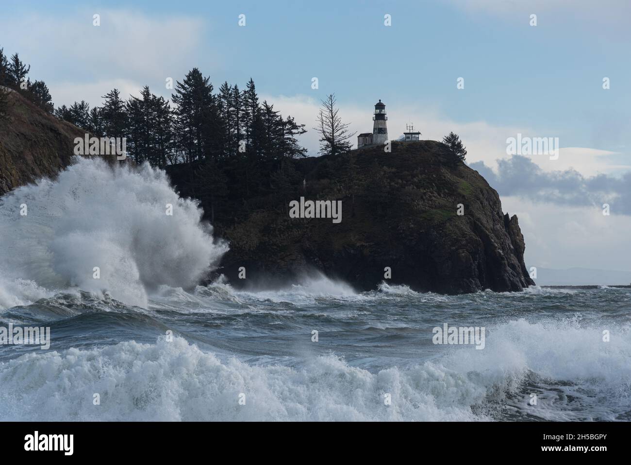 Mächtige stürmische Wellen, die während der Königsflut an der Washingtoner Küste, Cape Disappointment und im Pazifischen Nordwesten unter Klippen und Lichthaus krachen Stockfoto