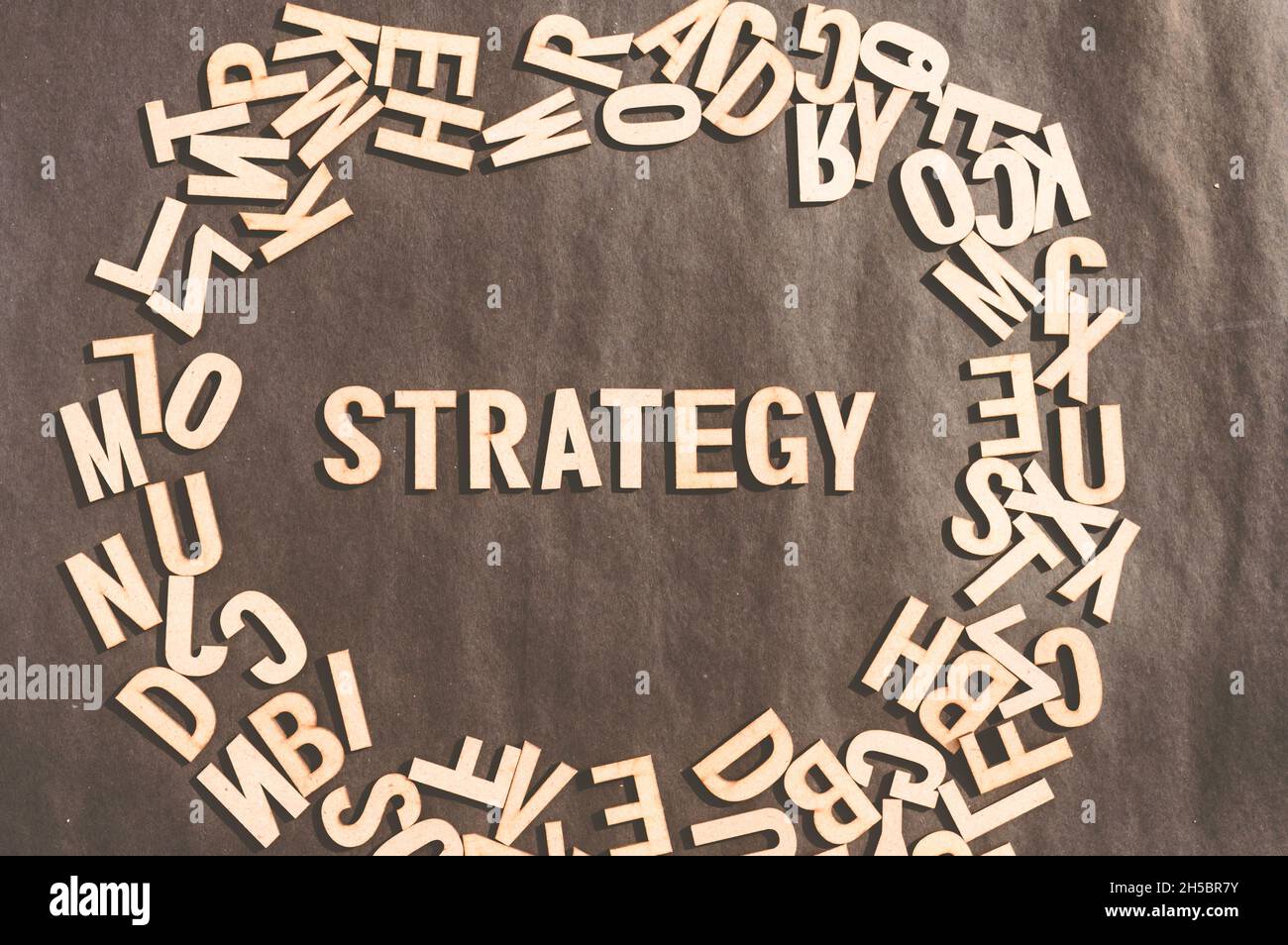 Strategie Wort in Holzwürfel Alphabet Buchstaben Draufsicht auf Einem rustikalen Papier Hintergrund. Stockfoto