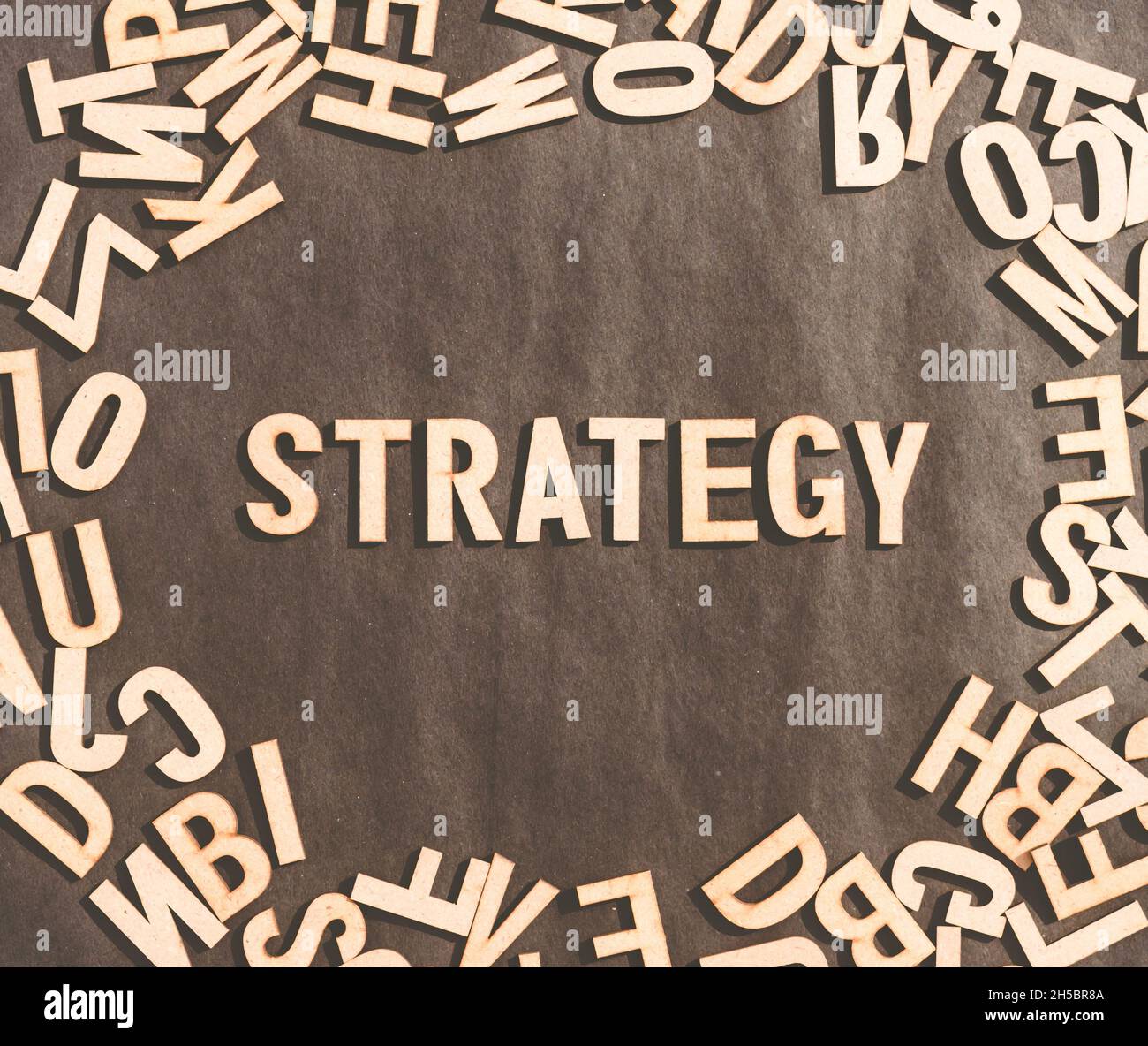 Strategie Wort in Holzwürfel Alphabet Buchstaben Draufsicht auf Einem rustikalen Papier Hintergrund. Stockfoto