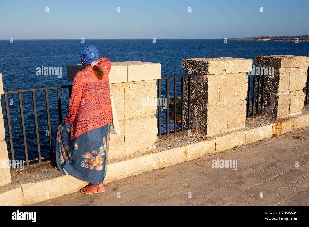 Sizilien, Siracusa, Ortigia - 20. Juli 2021: Menschen, die das Meer auf der Promenade von Ortigia betrachten Stockfoto
