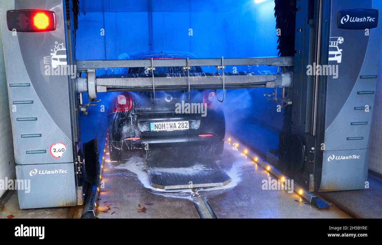 Itterbeck, Niedersachsen, Deutschland - Nov 3 2021 Ein schwarz-rotes Elektroauto wird in einer Autowäsche gewaschen. Smart EQ Forfour Electric Drive zweite Generation Stockfoto