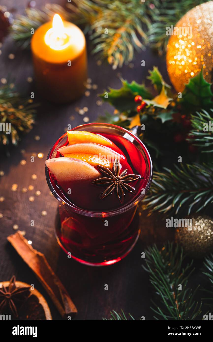 Weihnachtlicher Glühwein mit Gewürzen auf einem rustikalen Holztisch. Heißer Weihnachtsdrink. Weihnachtsdekoration. Nahaufnahme. Stockfoto