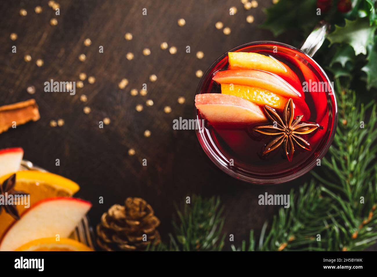 Weihnachtlicher Glühwein mit Gewürzen auf einem rustikalen Holztisch. Heißer Weihnachtsdrink. Weihnachtsdekoration. Nahaufnahme. Stockfoto