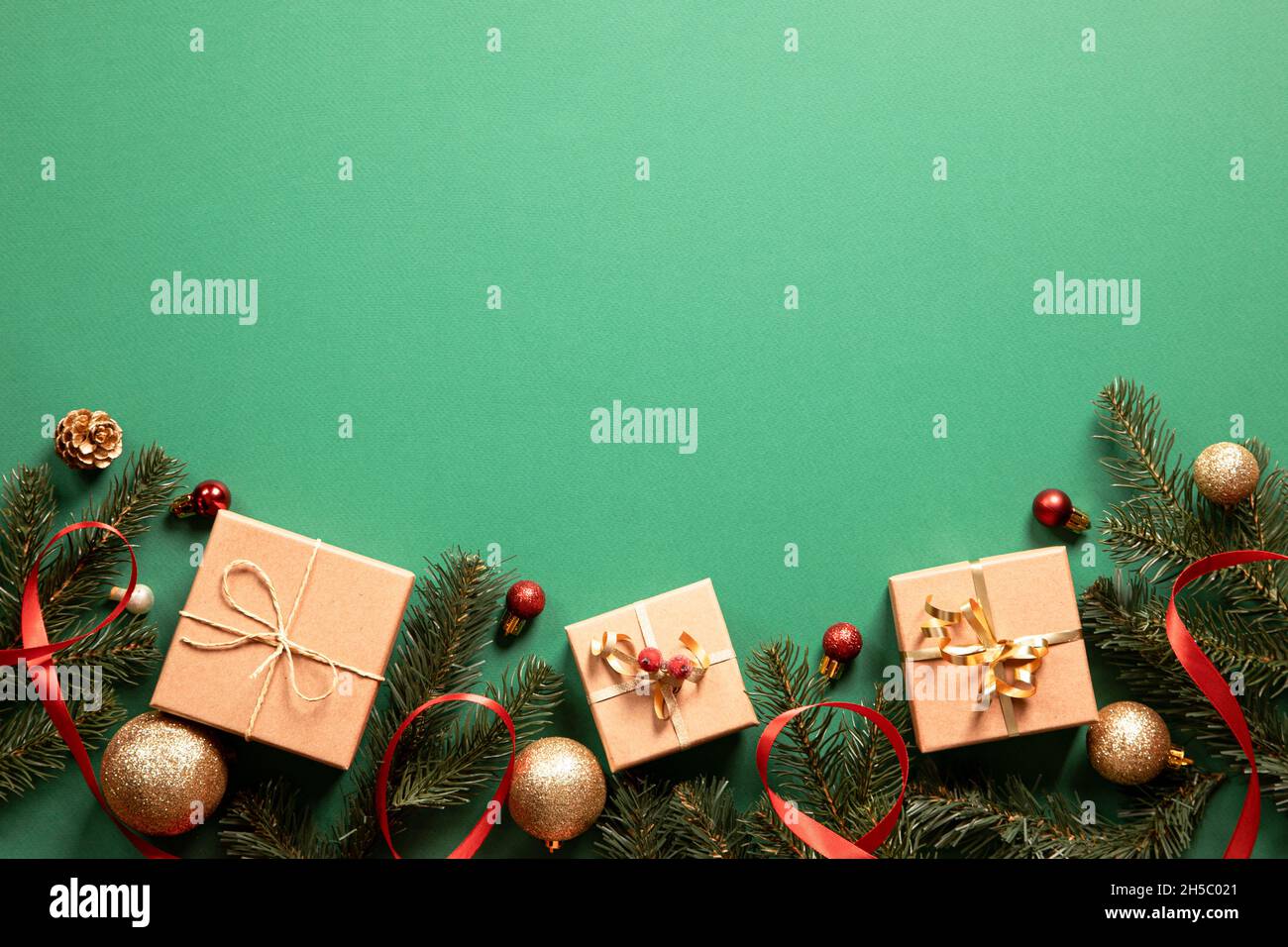 weihnachts-Geschenkboxen mit weihnachts-Accessoires auf grünem Hintergrund. Vorbereitung auf die Feiertage. Draufsicht mit Kopierbereich. Stockfoto