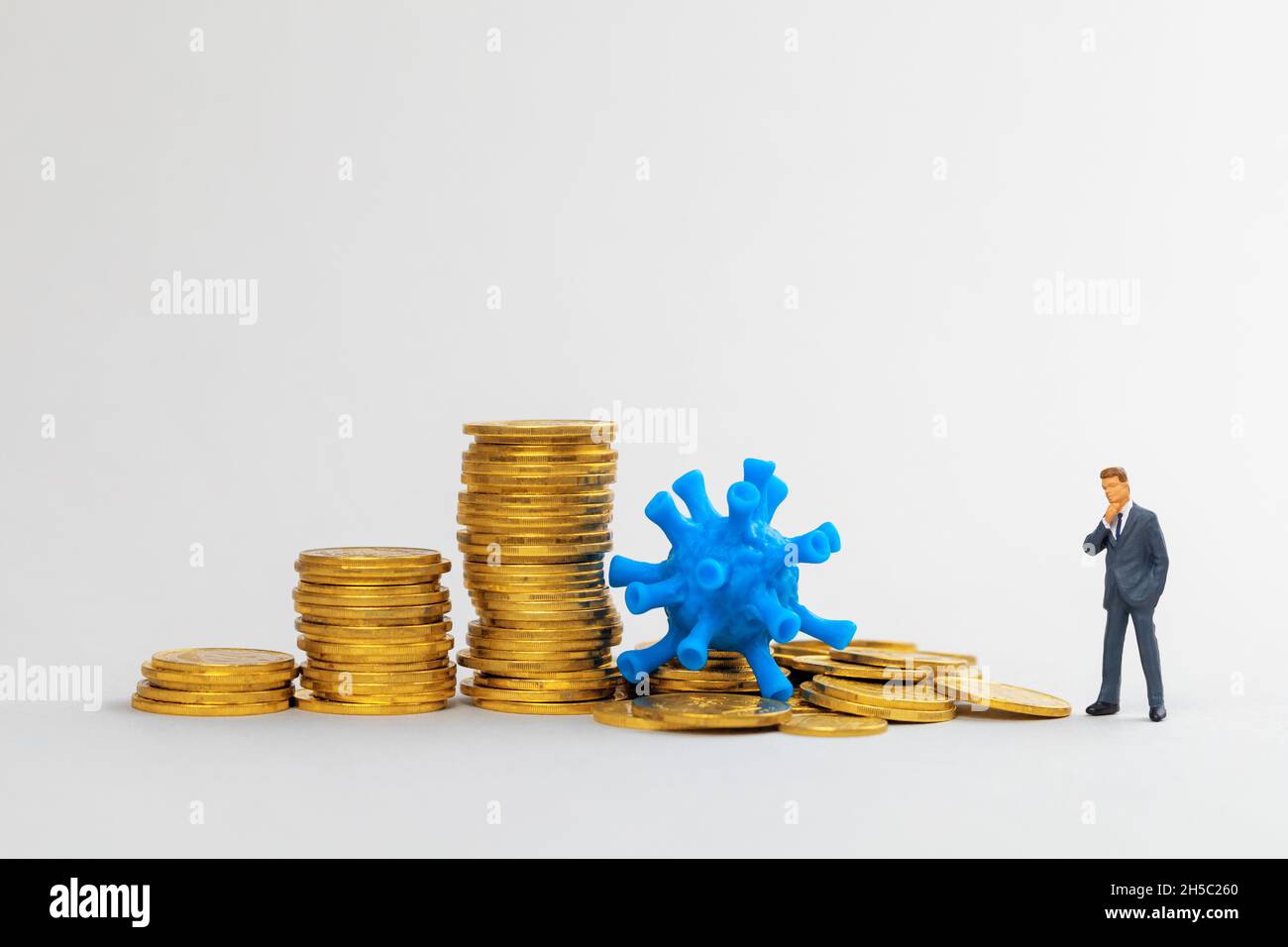 Virus hat das Geschäft zerstört. Das Virus zerschlug einen Stapel Münzen. Stockfoto