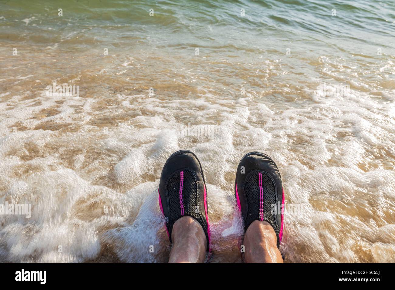 Schöne Aussicht auf Badeschuhe zu Füßen eines Mannes vor dem Hintergrund Meer. Griechenland. Stockfoto