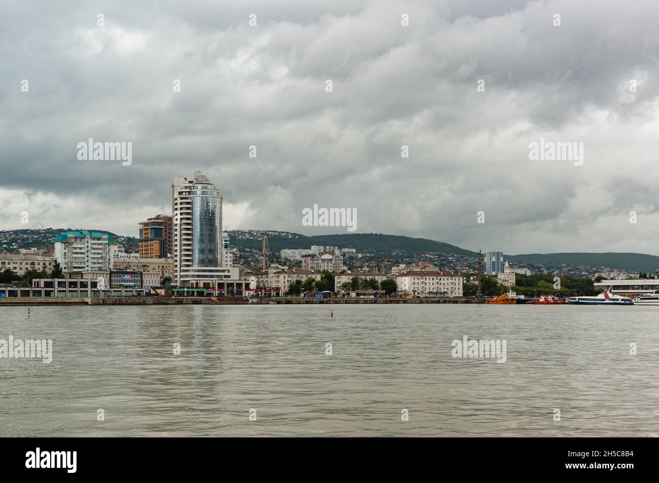 Noworossijsk, Russland, 13. August 2021: Panoramablick vom westlichen Pier auf den zentralen Bezirk der modernen südlichen Stadt an einem bewölkten Sommertag Stockfoto