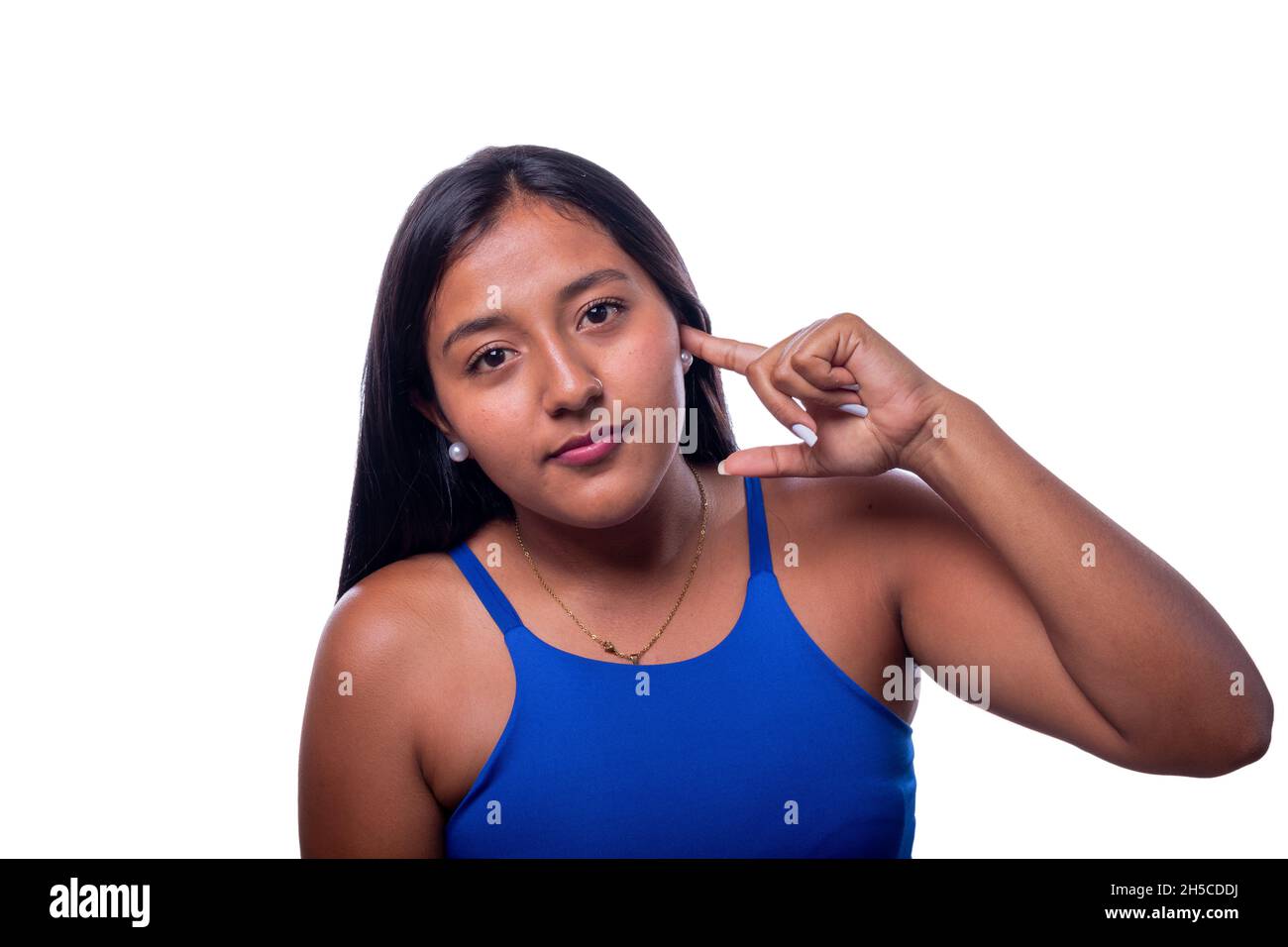 Schwarze Frau, die mit ihrem Finger anzeigt, dass sie taub ist. Eine lateinische Frau indigener Herkunft deutet darauf hin, dass sie nicht hört, indem sie auf ihr Ohr zeigt. Stockfoto