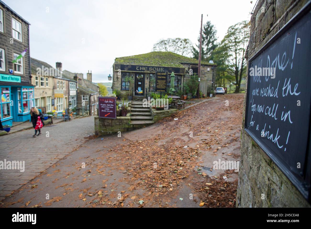 Haworth ist ein Touristenziel, das für seine Verbindung mit den Schwestern von Brontë und das erhaltene Erbe Keighley und Worth Valley Railway bekannt ist. Das Dorf liegt in den Pennine Hills von West Yorkshire in Großbritannien und ist bekannt für seine steile Kopfsteinpflasterstraße. Stockfoto