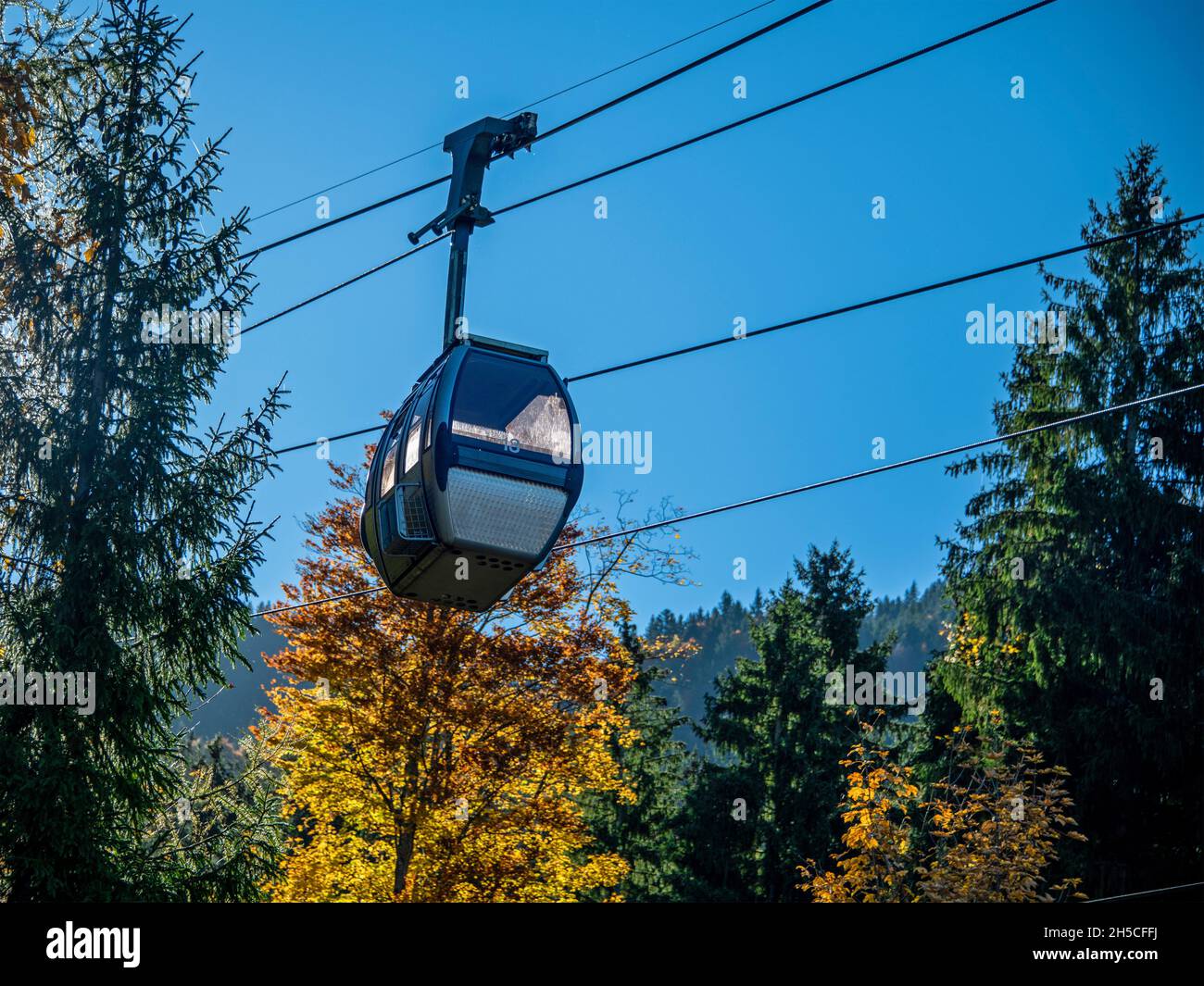 Hütte einer Seilbahn gegen die bunten Bäume an einem Herbsttag mit blauem Himmel Stockfoto