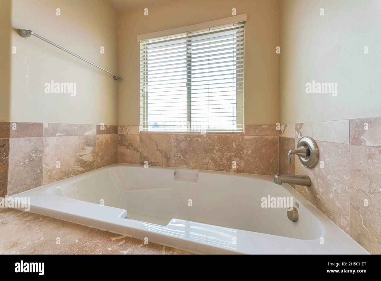 Badewanne mit Alkoven im Badezimmer mit matter Marmorkachelumrandung Stockfoto