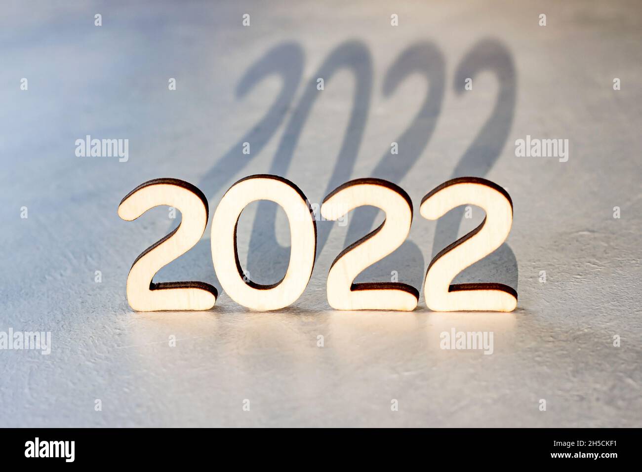 Holznummern 2022 Silhouette mit Schatten auf hellem Hintergrund. Neujahrsbeginn Glückwünsche und Planungskonzept. Stockfoto