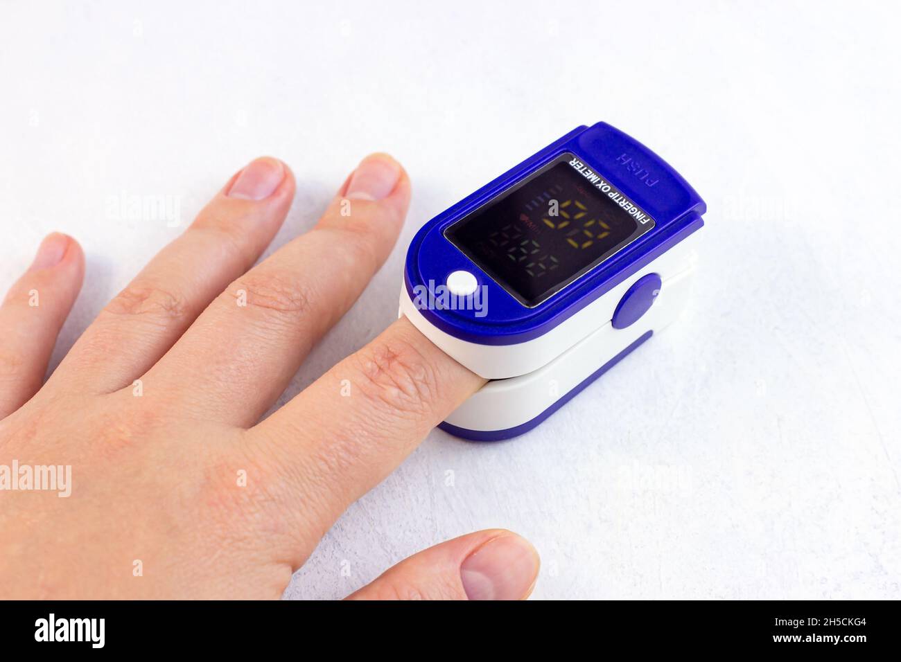 Frauenhand mit medizinischem Fingertipp-Pulsoximeter zur Überprüfung der Sauerstoffsättigung bei kovidem Virusdesfall. SpO2-Überwachung und Herzfrequenzmessung Stockfoto