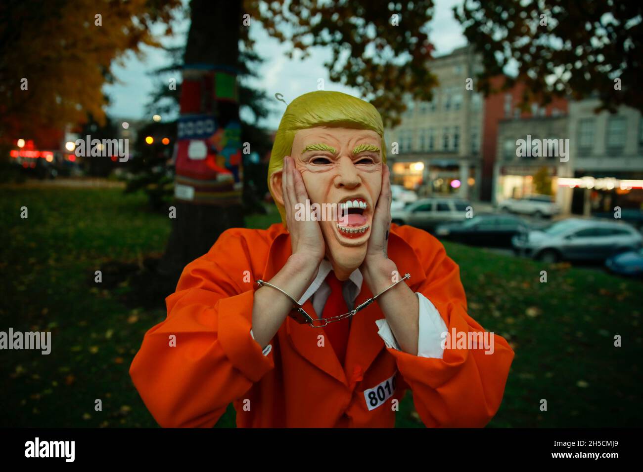 Ein Protestler, der eine Donald Trump-Maske trägt, und ein Gefängnissprunganzug aus einem Kostümgeschäft verlässt den Platz, nachdem die Nobody is Above the Law - Protect Mueller Rapid Response Rallye, 8. November 2018 in Bloomington, Ind Stockfoto