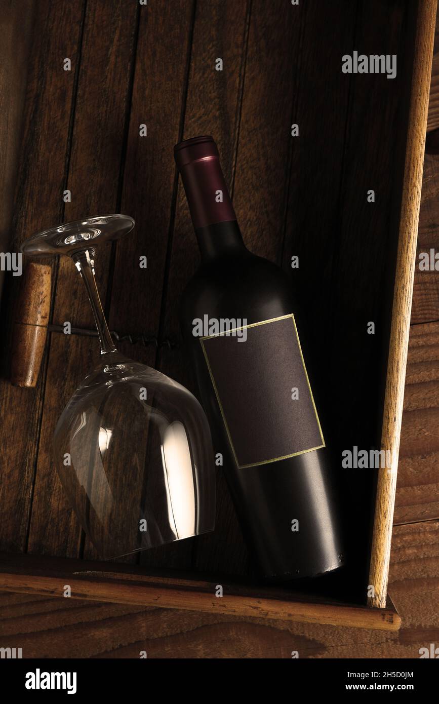 Wein Stillleben: Flach lagenWeinflasche Weinglas und Korkenzieher in einer Holzkiste mit warmem Seitenlicht. Vertikales Format mit Kopierbereich. Stockfoto