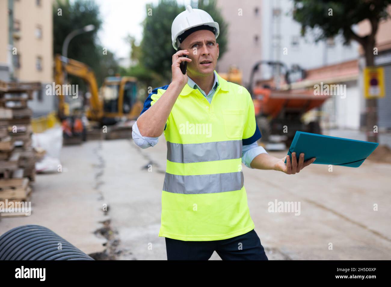 Der junge Ingenieur spricht auf einem Mobiltelefon Stockfoto