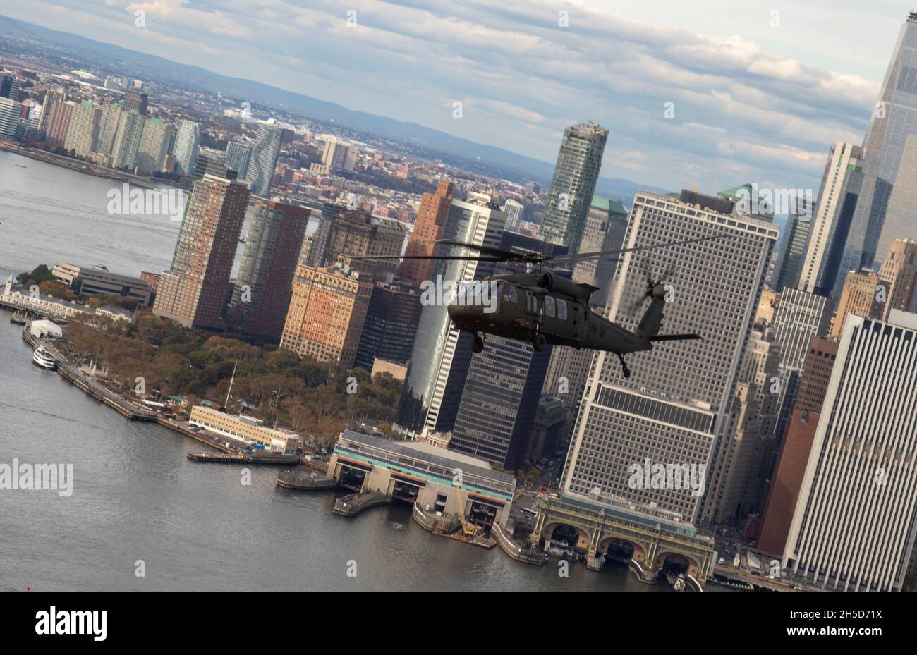 Eine New York Army National Guard UH-60 fliegt durch Lower Manhattan, während sie Offiziere und unbestellte Offiziere trägt, die am Kurs der New York Army National Guard für die dichten Stadtführer teilnehmen, um den Teilnehmern ein Gefühl für das Layout der Stadt zu vermitteln. Der 5-tägige Kurs ist darauf ausgerichtet, Personalverantwortliche und leitende, nicht beauftragte Beamte in der Planung und Ausführung von Operationen in komplexen städtischen Umgebungen zu Schulen und auszubilden. (USA Armee-Foto von SPC. Marla Ogden) Stockfoto Eine New York Army National Guard UH-60 fliegt durch Lower Manhattan, während sie Offiziere und unbestellte Offiziere trägt, die am Kurs der New York Army National Guard für die dichten Stadtführer teilnehmen, um den Teilnehmern ein Gefühl für das Layout der Stadt zu vermitteln. Der 5-tägige Kurs ist darauf ausgerichtet, Personalverantwortliche und leitende, nicht beauftragte Beamte in der Planung und Ausführung von Operationen in komplexen städtischen Umgebungen zu Schulen und auszubilden. (USA Armee-Foto von SPC. Marla Ogden) Stockfoto