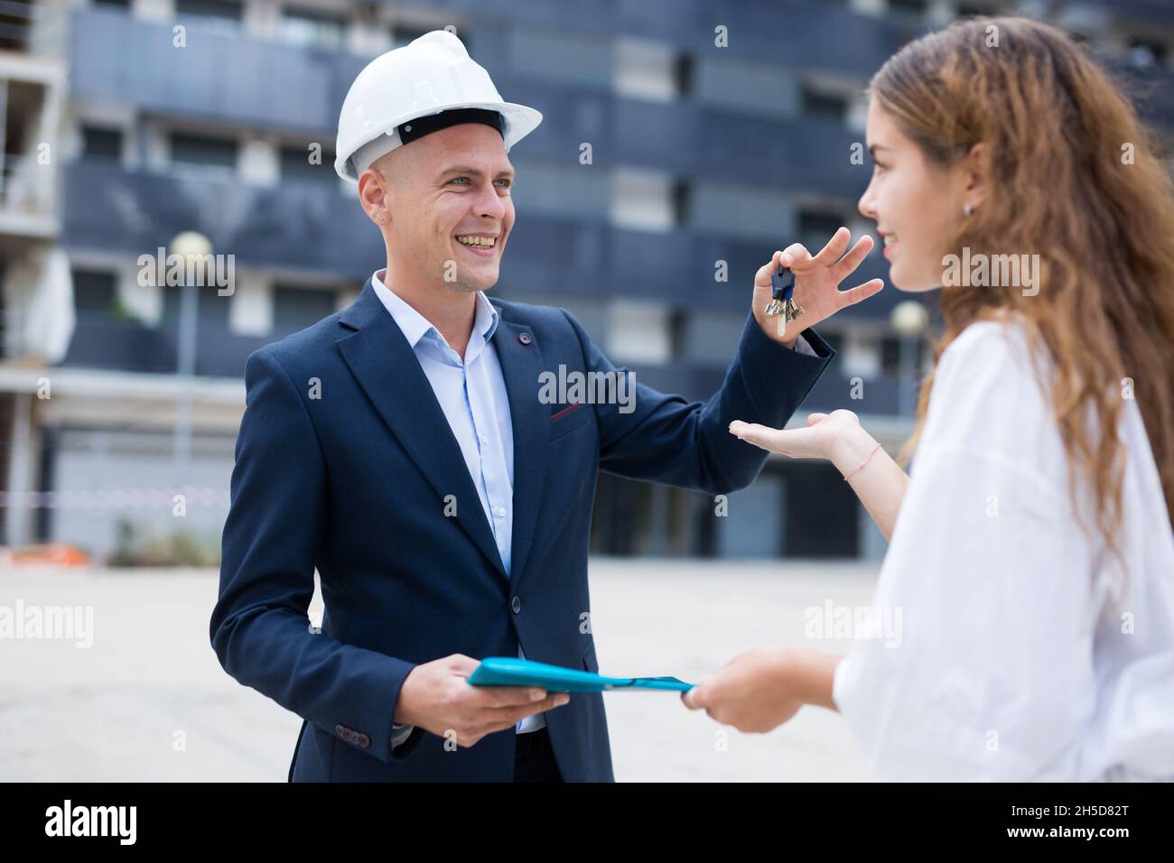 Frau, die Schlüssel vom Immobilienmanager erhält Stockfoto