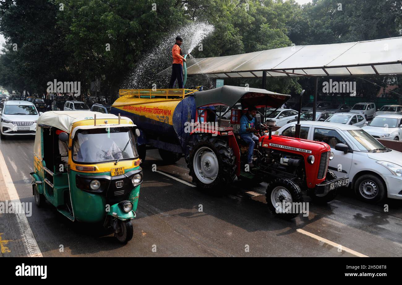 Neu-Delhi, Indien. November 2021. Ein Arbeiter sprüht Wasser auf die Autos, um die Luftverschmutzung aus der Atmosphäre vor dem Obersten Gerichtshof von Indien einzudämmen.in Delhi war die Luftqualität in fünf Jahren nach der Diwali-Feier so schlecht, zusammen mit dem Stoppelbrand in Uttar Pradesh, Punjab und Haryana. Menschen, die in Delhi und den angrenzenden Gebieten leben, finden es schwierig, frische Luft zu atmen und das Risiko von Atemwegserkrankungen zu minimieren. (Foto von Naveen Sharma/SOPA Images/Sipa USA) Quelle: SIPA USA/Alamy Live News Stockfoto