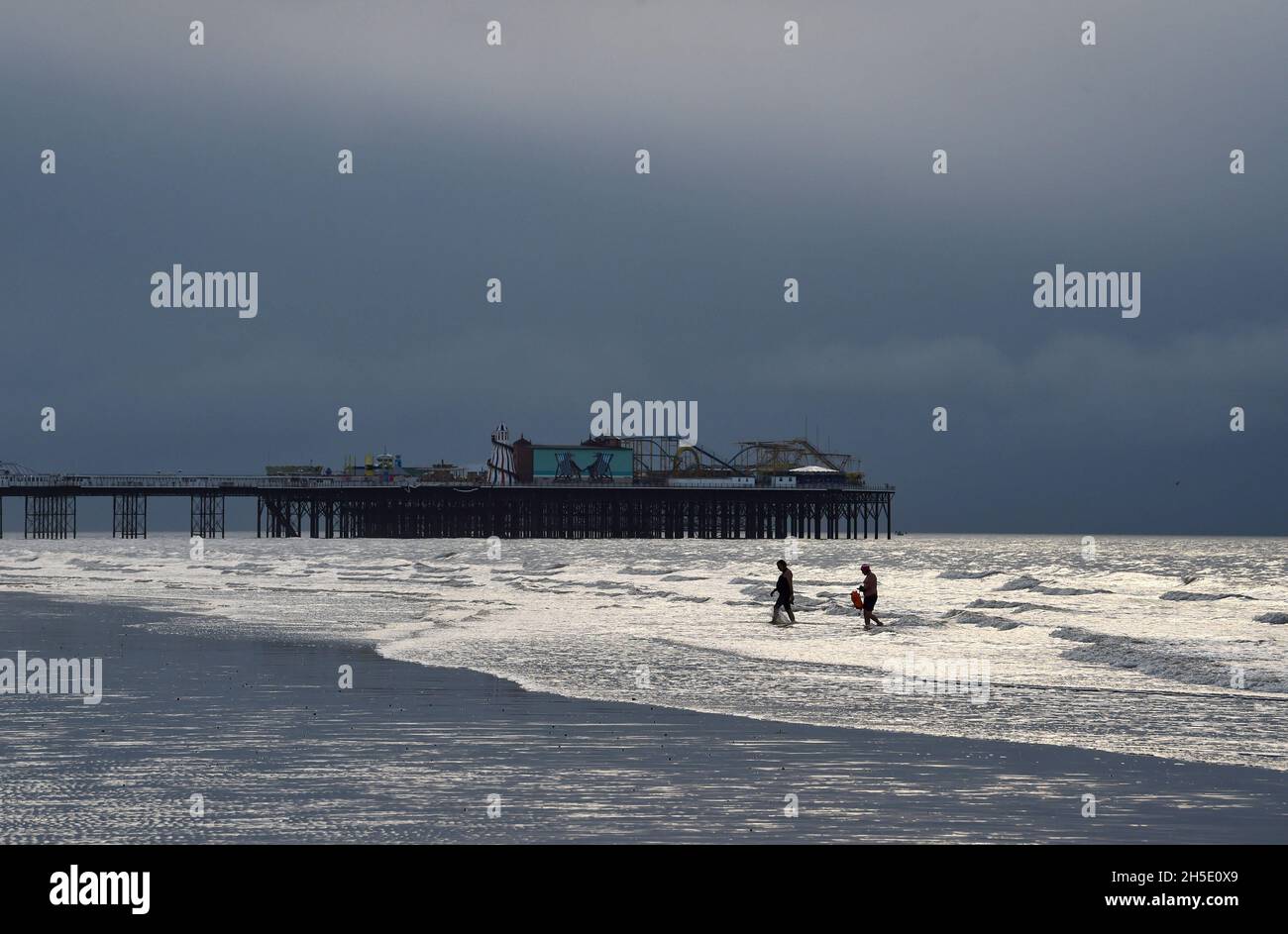 Brighton UK 19. November 2021 - Schwimmer genießen die Ebbe am Brighton Beach an einem bewölkten Morgen entlang der Südküste mit gelegentlichem Sonneneinbruch durch die dunklen Wolken : Credit Simon Dack / Alamy Live News Stockfoto