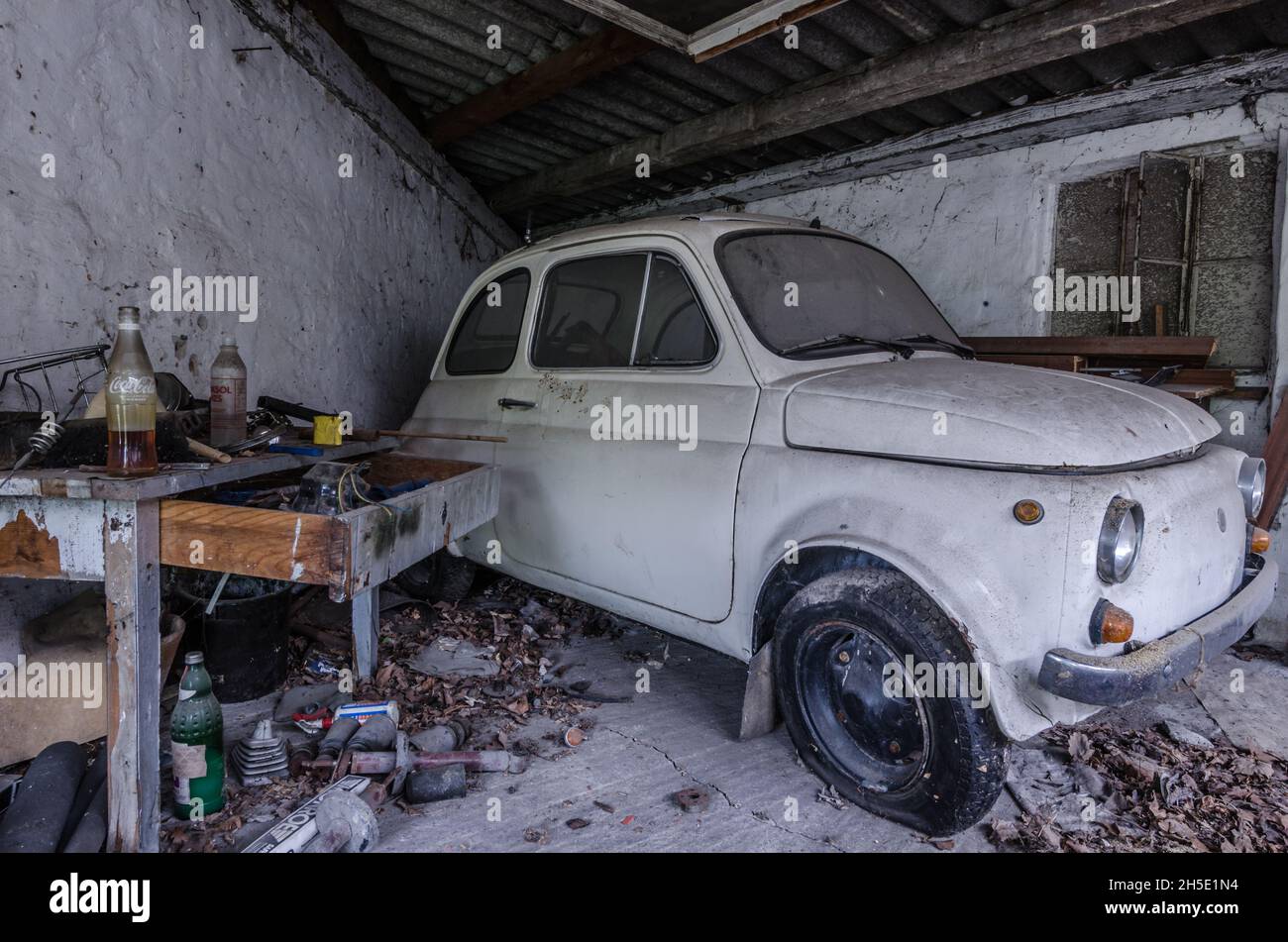 Kleines Auto in einer verlassenen Garage Stockfoto